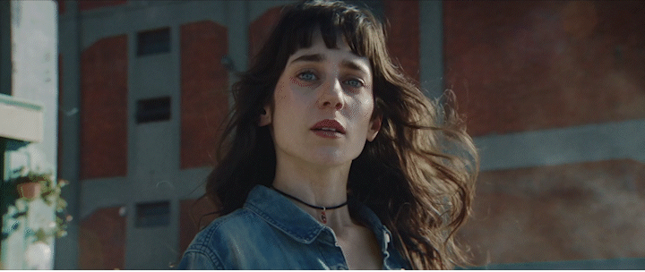a woman in a denim jacket standing in front of a building