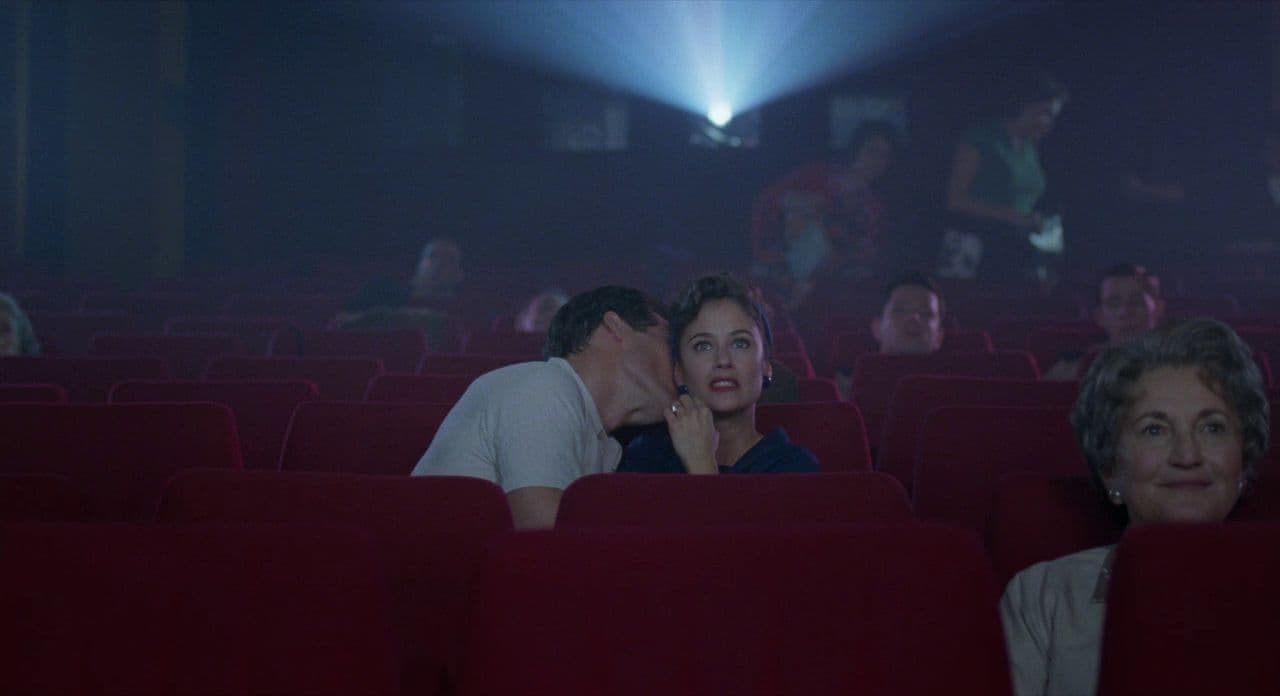 a man and a woman kissing in a theater