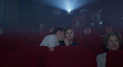 a man and a woman kissing in a theater