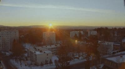 the sun is setting over a city in winter