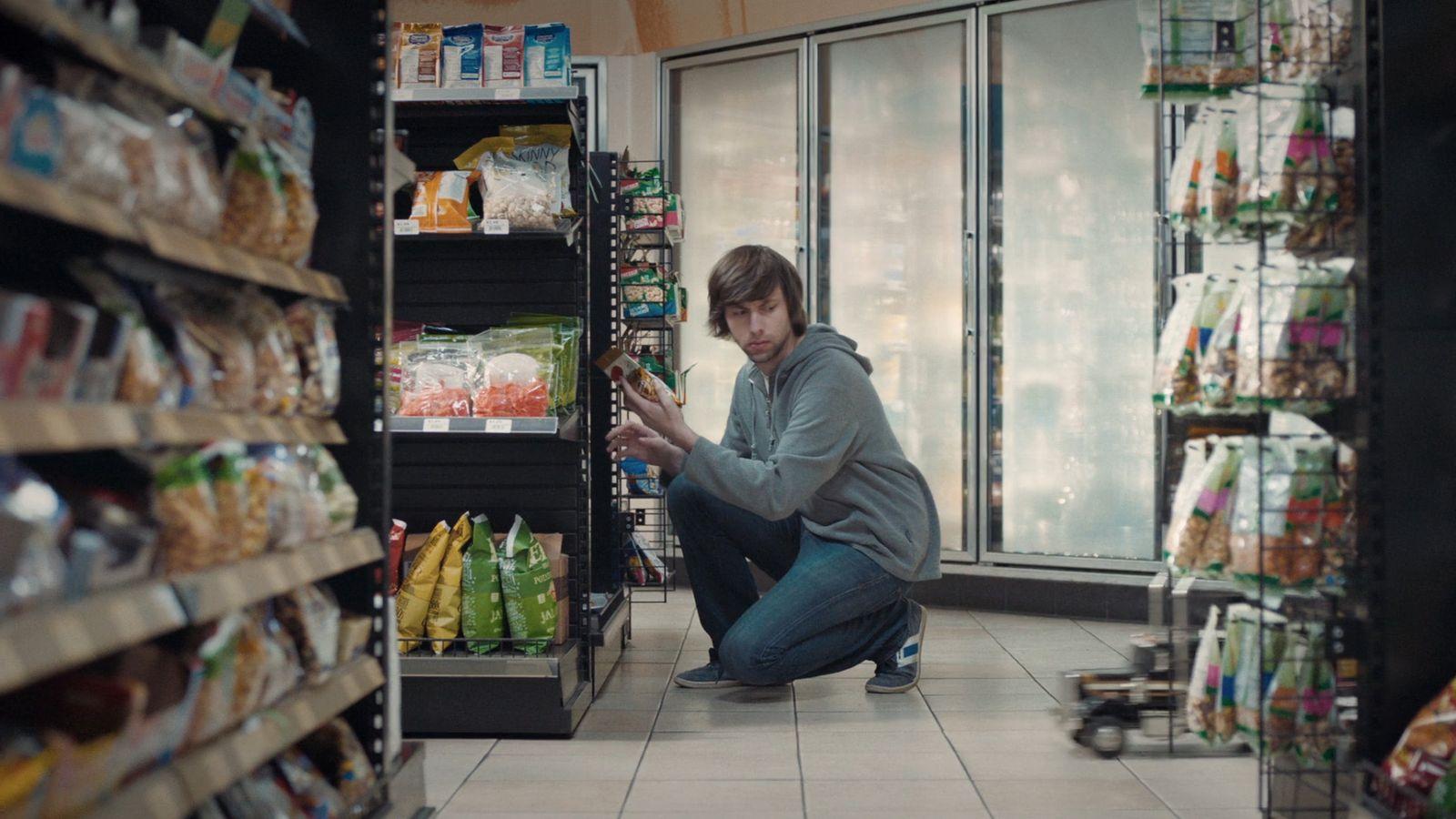 a man kneeling down in a grocery store