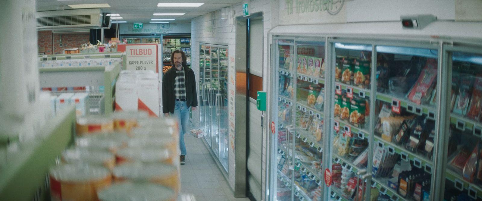 a woman is walking down the aisle of a store