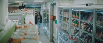 a woman is walking down the aisle of a store
