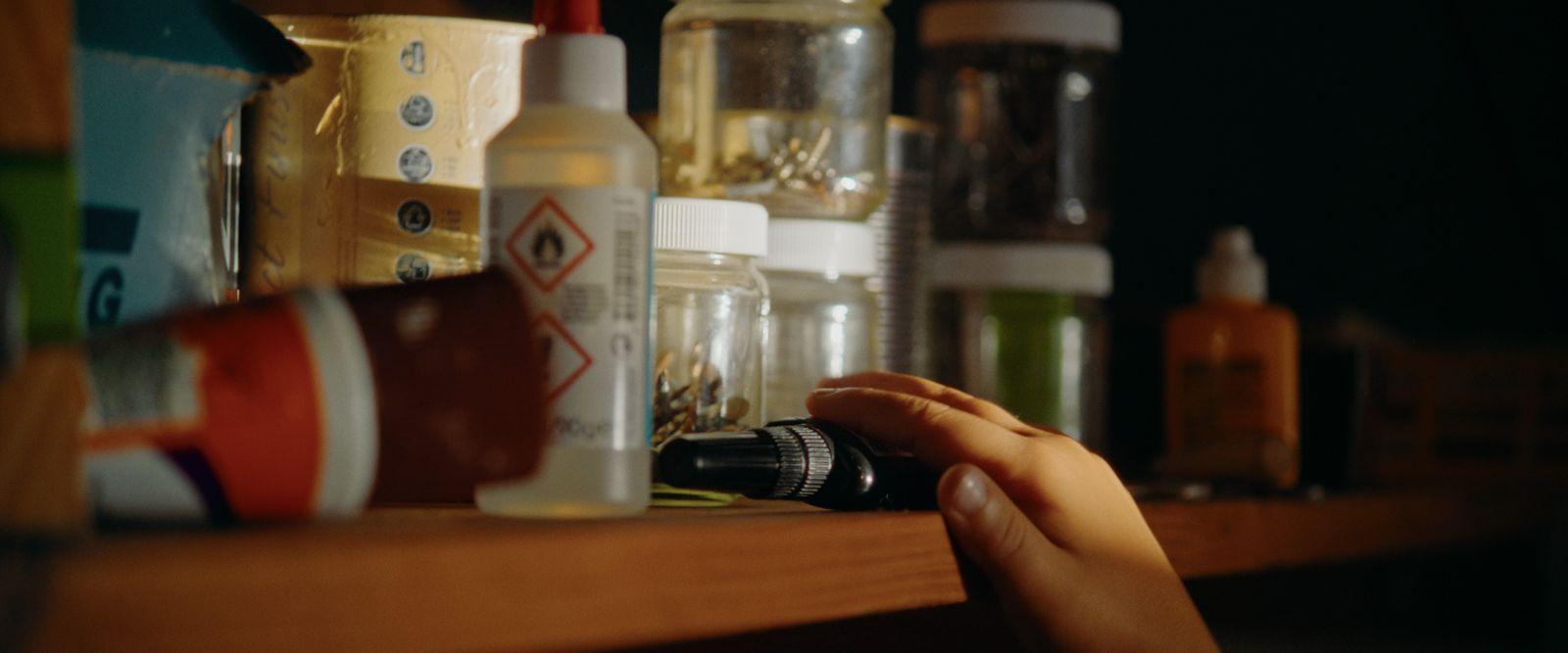 a person holding a camera in front of a shelf