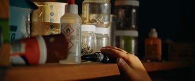 a person holding a camera in front of a shelf