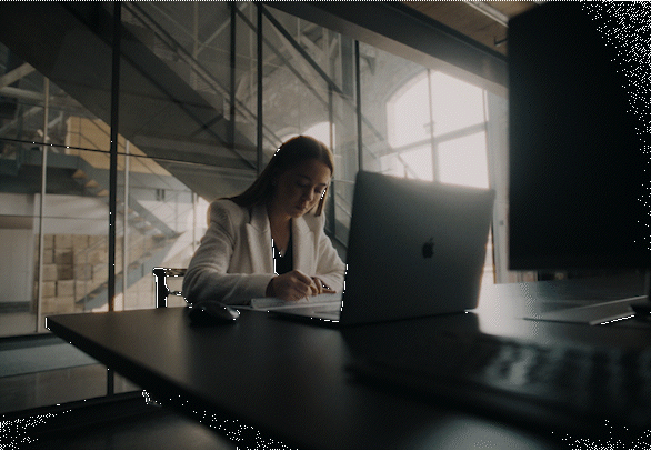 a woman sitting in front of a laptop computer
