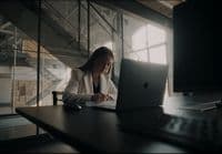 a woman sitting in front of a laptop computer
