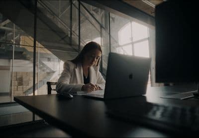 a woman sitting in front of a laptop computer