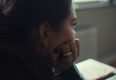 a woman sitting at a table with her hand on her face