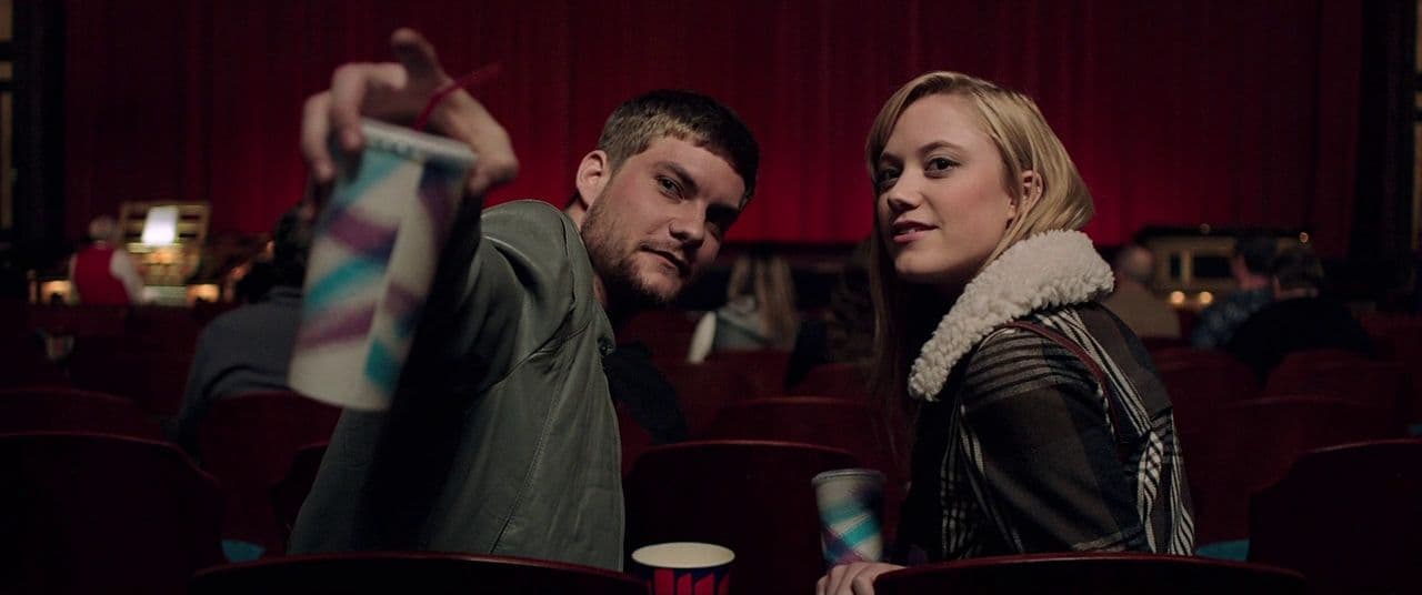 a man standing next to a woman in a theater
