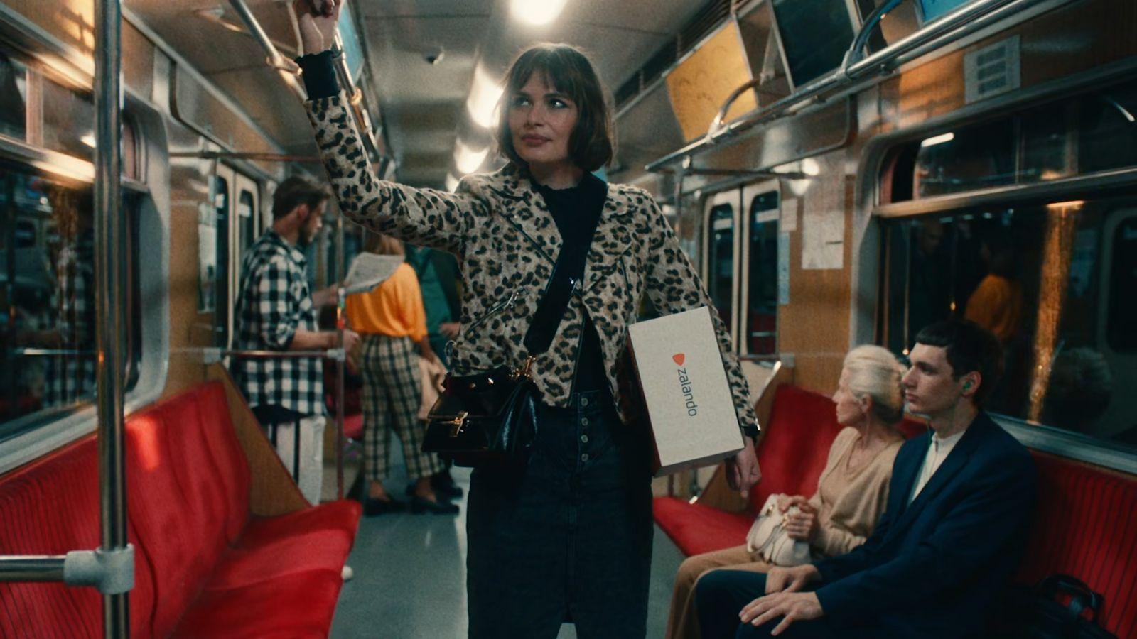 a woman standing on a train with her hand up