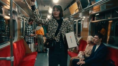 a woman standing on a train with her hand up