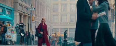 a group of people walking down a street next to tall buildings