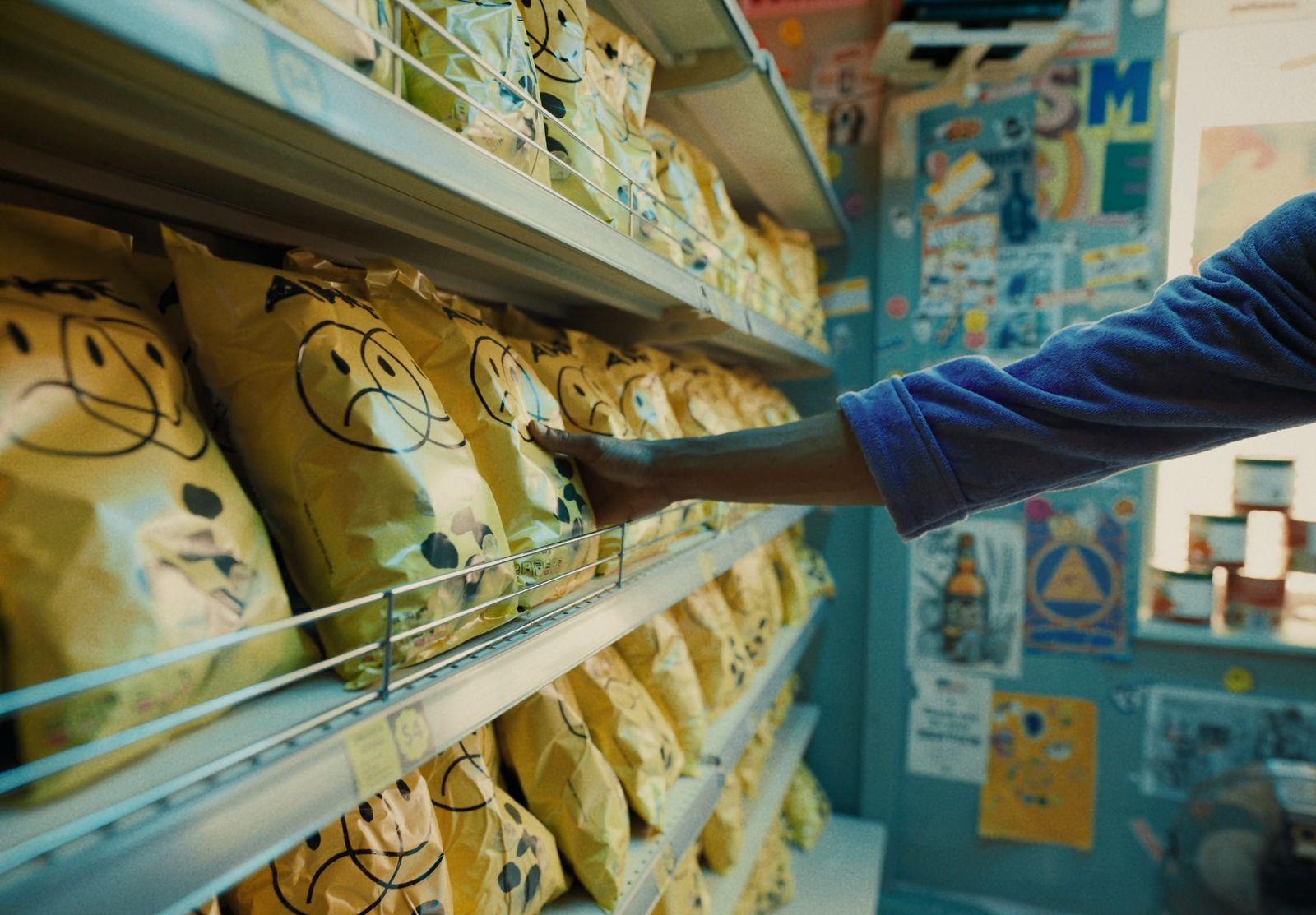 a person reaching for a bag of food in a store
