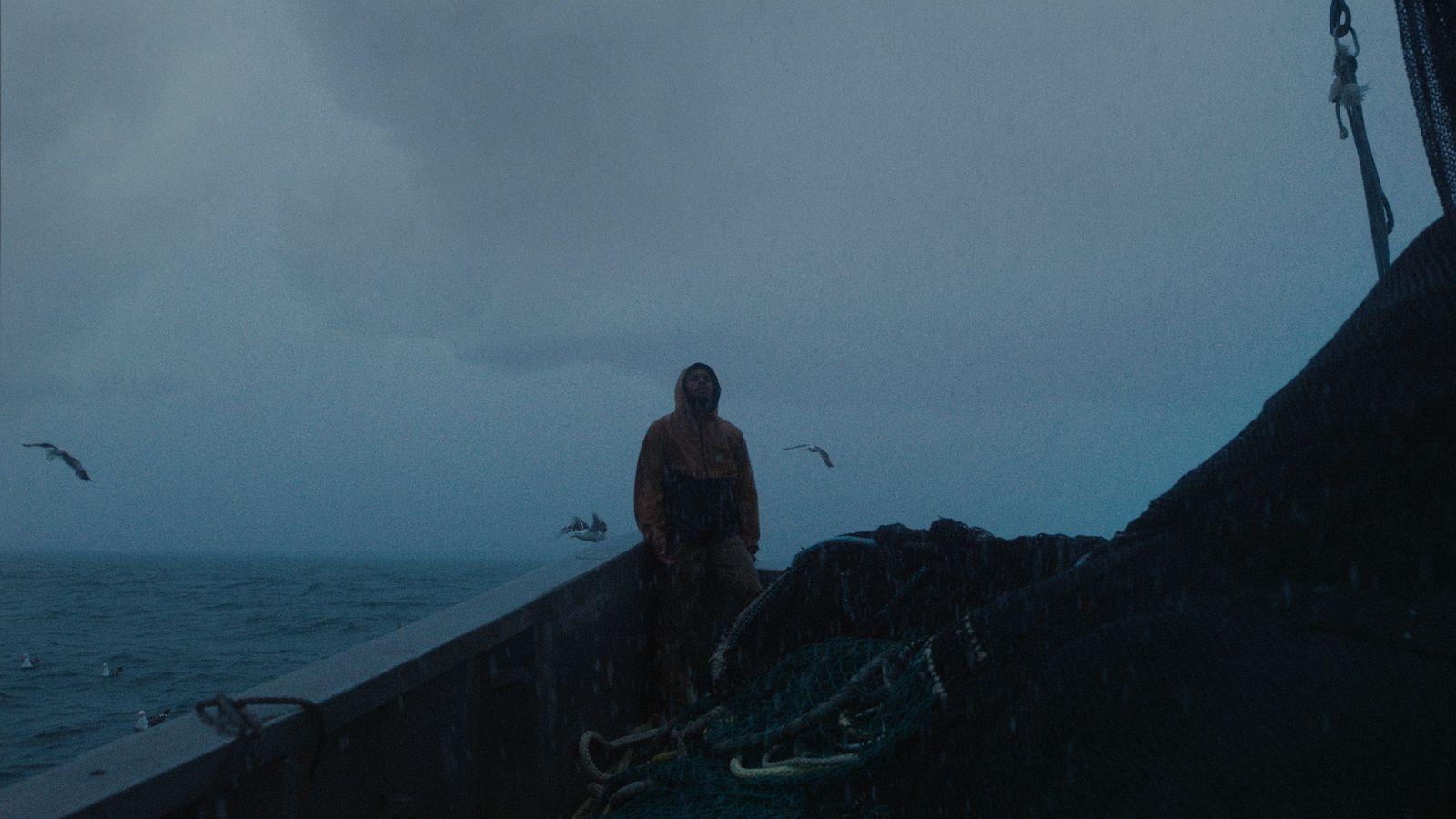 a man standing on a boat in the rain
