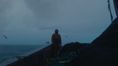 a man standing on a boat in the rain