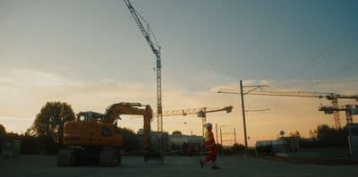 a construction site with a crane and a man walking