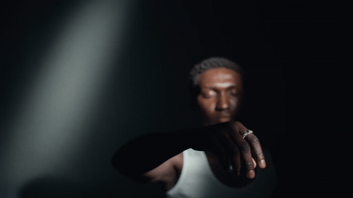 a man in a white tank top is holding his hand out