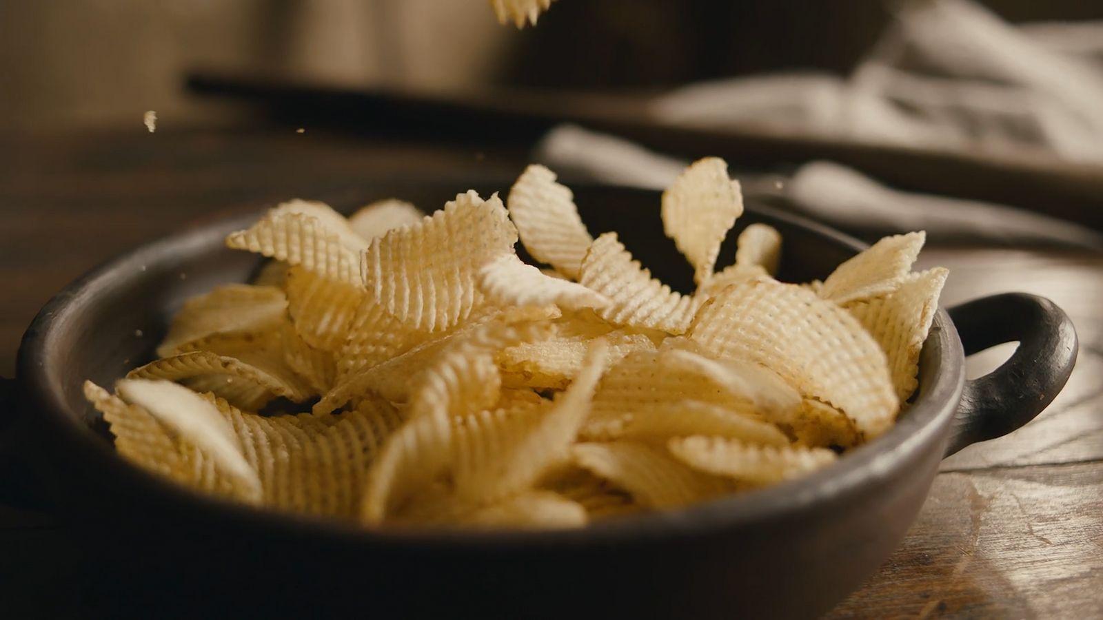 a bowl filled with chips on top of a wooden table