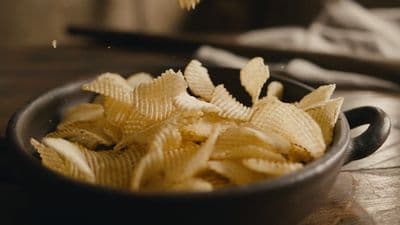 a bowl filled with chips on top of a wooden table