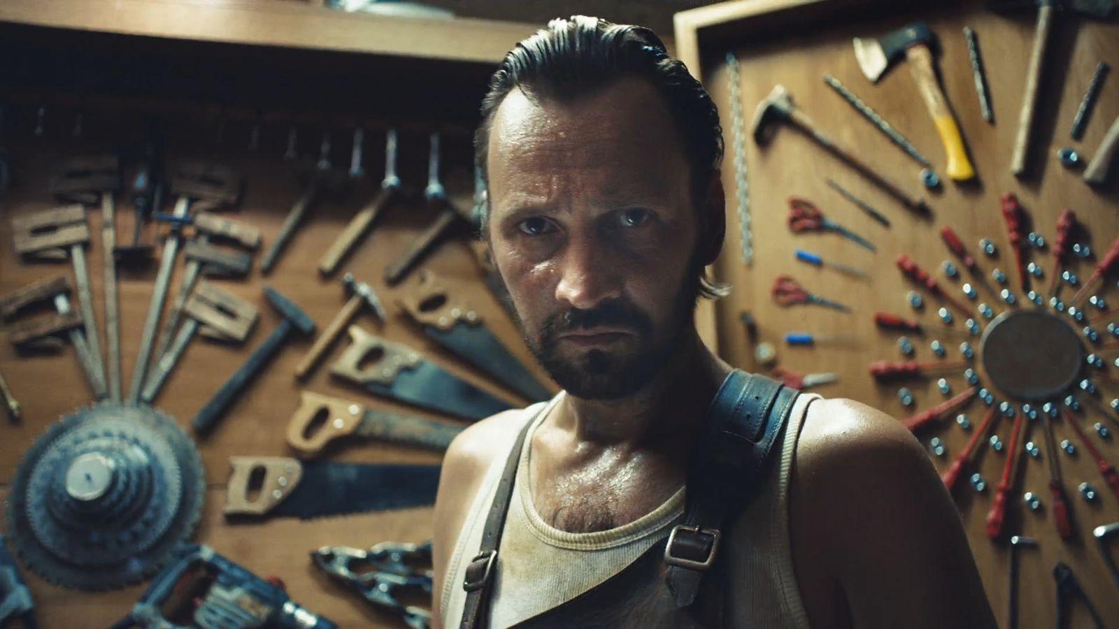 a man standing in front of a bunch of tools