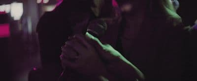 a woman holding a microphone in a dark room