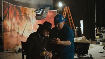 a man standing next to another man on a cell phone