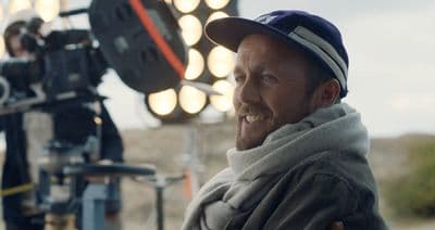 a man with a hat and a camera in front of him