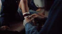 a person sitting on the ground with a cigarette in their hand