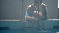 a man and a woman sitting in a swimming pool