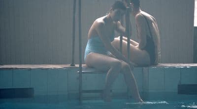 a man and a woman sitting in a swimming pool