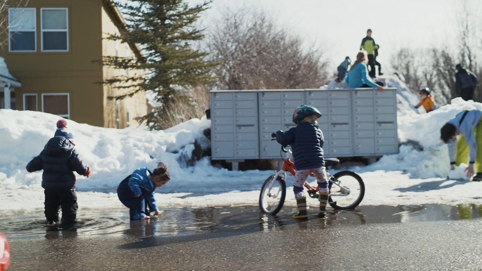 a group of people standing around a child on a bike