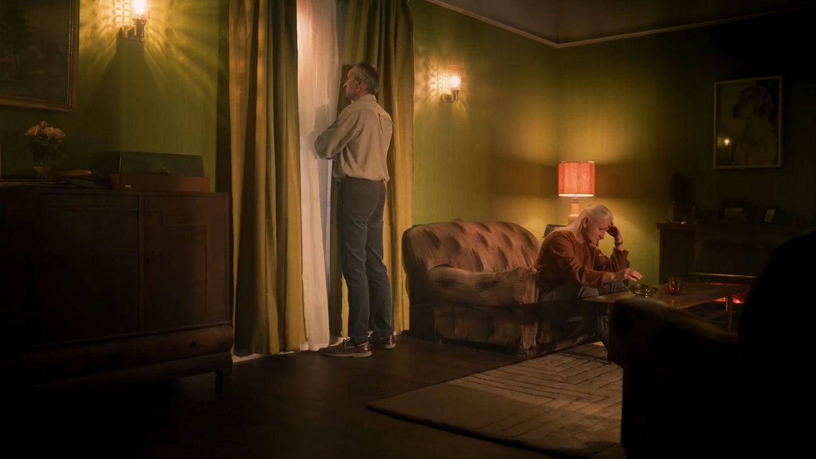 a man standing next to a woman in a living room
