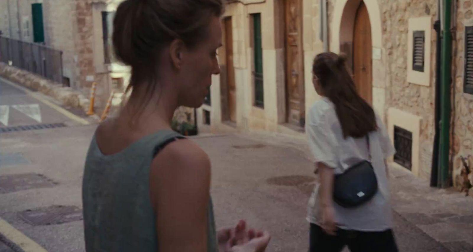 a woman walking down a street next to another woman