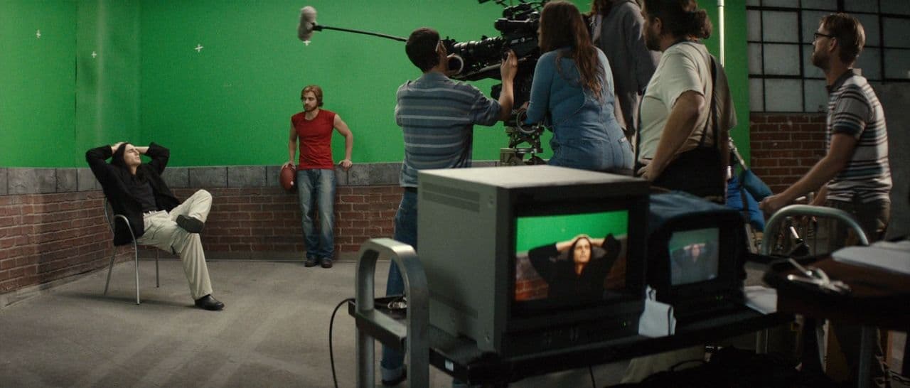 a group of people standing around a green screen