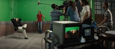 a group of people standing around a green screen