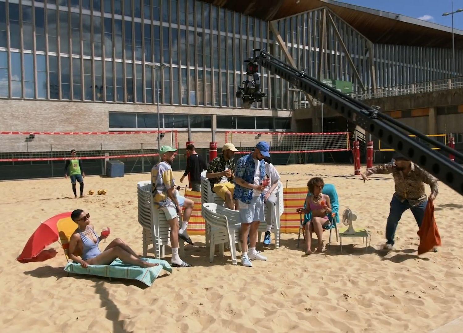 a group of people sitting on top of a sandy beach