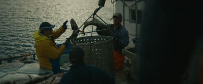 a group of men standing on top of a boat
