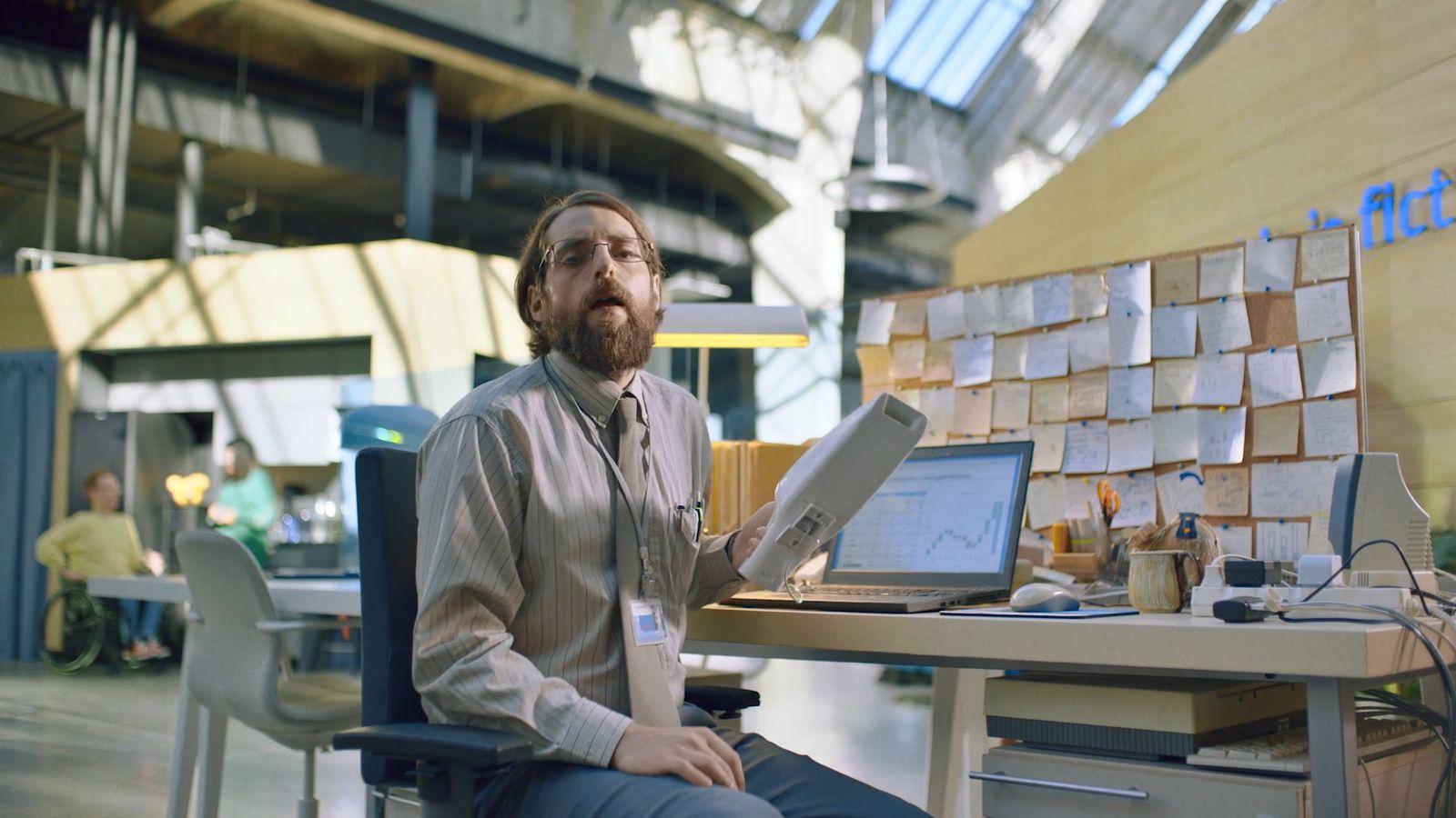 a man sitting at a desk with a laptop