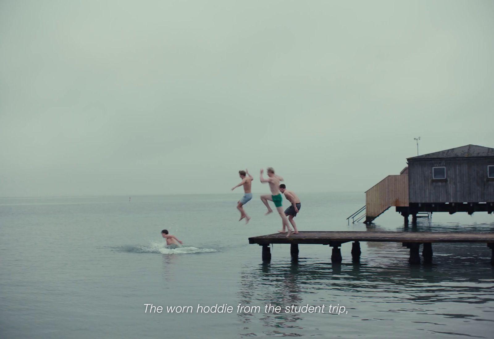 a group of people jumping off a dock into the water
