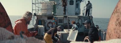 a group of people standing on top of a boat
