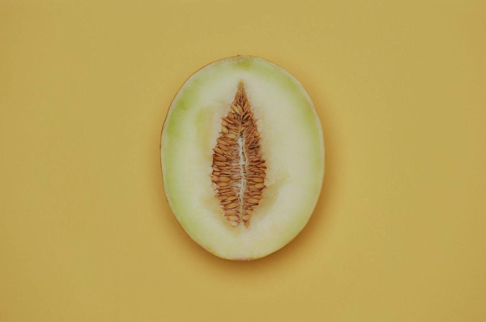 a half eaten melon on a yellow background