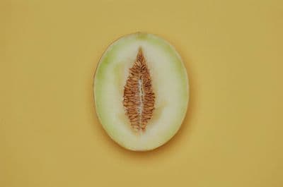 a half eaten melon on a yellow background