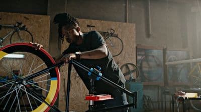 a man working on a bicycle in a garage