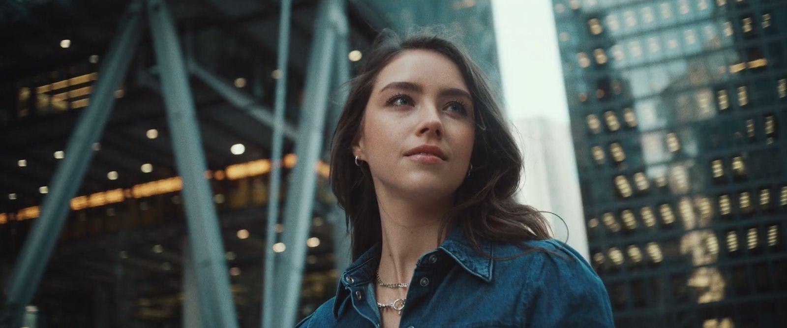 a woman standing in front of a tall building