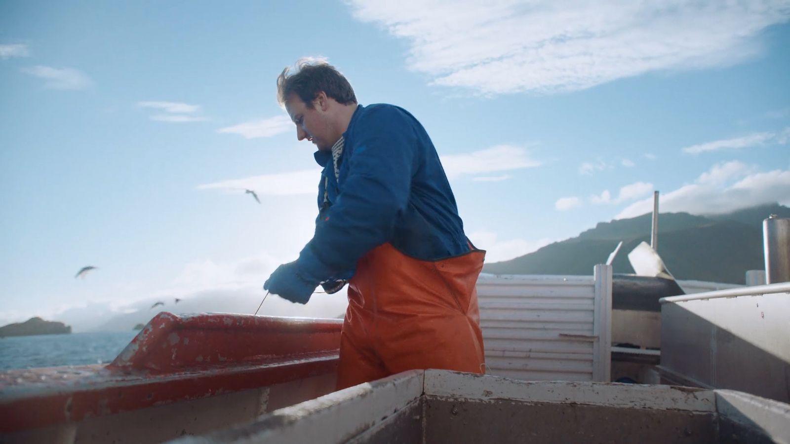 a man standing on top of a boat near the ocean