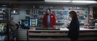 a man and a woman standing in front of a store counter