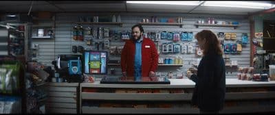 a man and a woman standing in front of a store counter