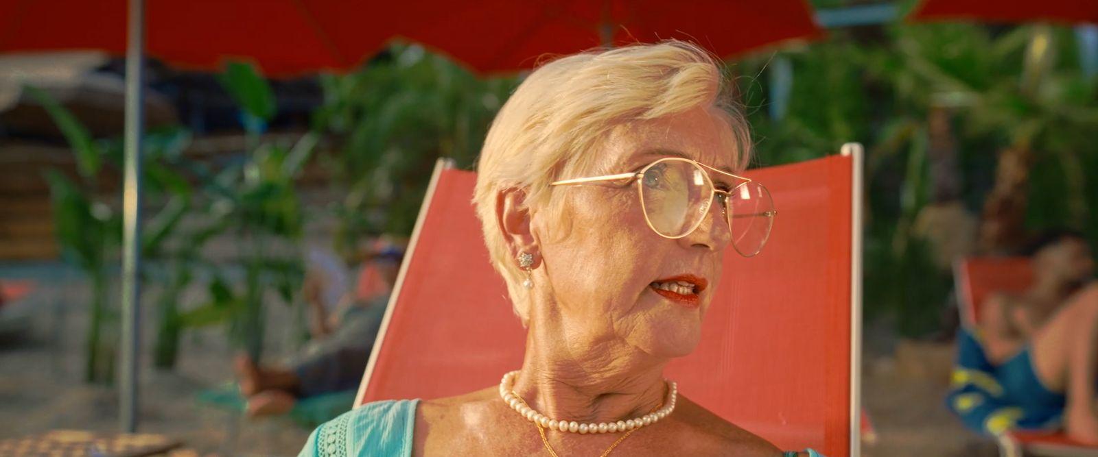 a woman wearing glasses sitting in a red chair