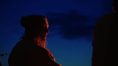 a man standing next to a woman in the dark